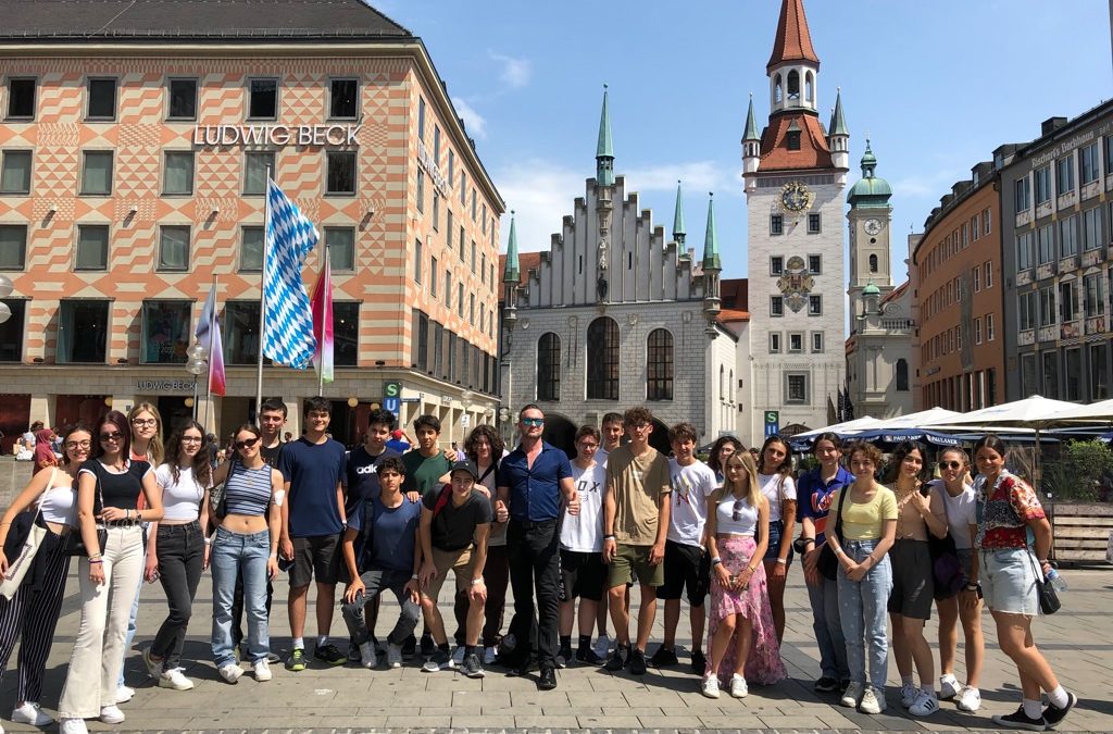 Schülergruppe auf Klassenfahrt in München auf dem Marienplatz mit Blick auf das Neue Rathaus.