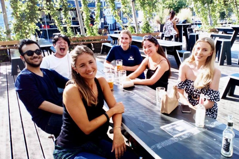 International language students sit together in a café in Berlin, enjoying their free time during a German course.