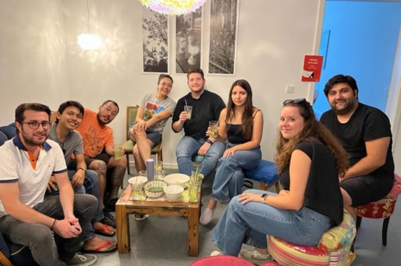 Internationale Sprachstudenten sitzen gemeinsam in einer Sprachschule in Köln und unterhalten sich in entspannter Atmosphäre.